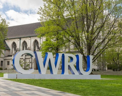 A campus setting with large block letters that read CWRU.