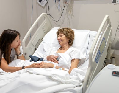 Photo of ICU patient and family member by her hospital bed.