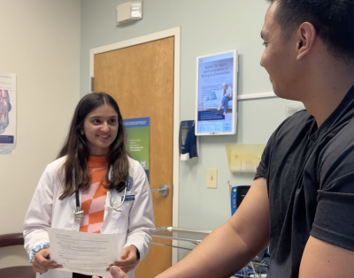 an medical student volunteer helping a patient at Horizons Community Clinic