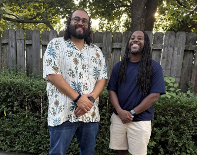 Juan Silva stands with a friend on a driveway.