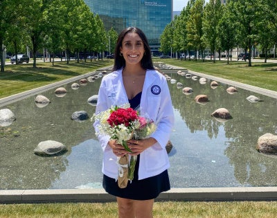 Riddhi Patel posing with flowers in front of the Cleveland Clinic