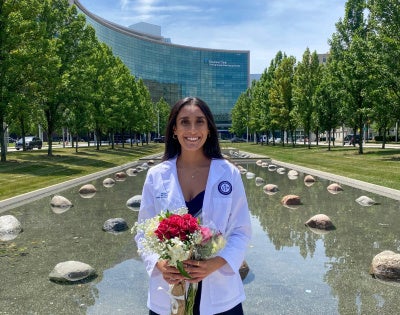 Riddhi Patel posing with flowers in front of the Cleveland Clinic