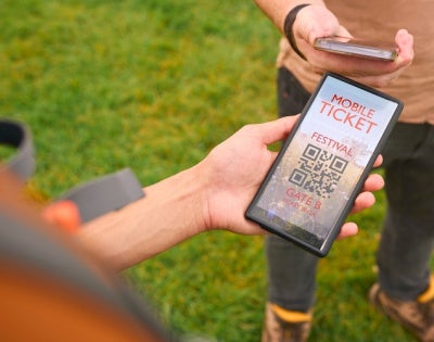 Close up of a person showing an E-ticket on a mobile phone