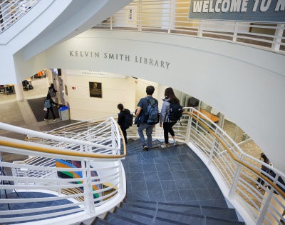 Two students walk down the spiral staircase at Kelvin Smith Library.