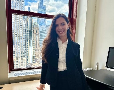 Anna Styer standing at desk in front of window in NYC