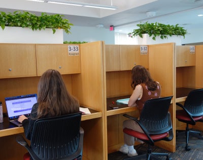 Two students work at graduate carrel desks at Kelvin Smith Library.