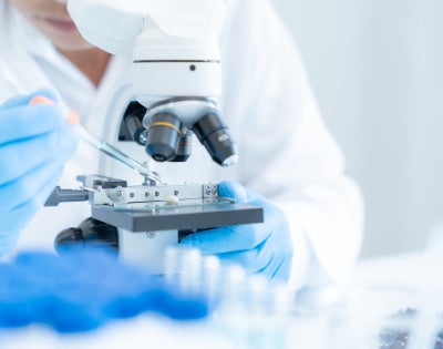 Photo of a medical researcher using a high-powered microscope.