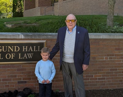 Ray November and his grandson, Liam, outside of the School of Law