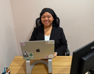 Sydney Jones sitting behind a desk with a laptop