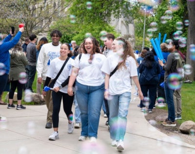 Happy students walk through bubbles at CWRU's annual Clap-Out event. 