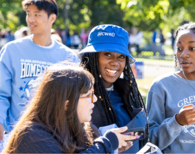 Students on campus, one wearing a Greek Life sweatshirt
