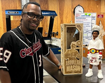 Photo of Mike Crawford in Sears think[box] posing with a custom-made 3D-printed figure and laser-engraved box