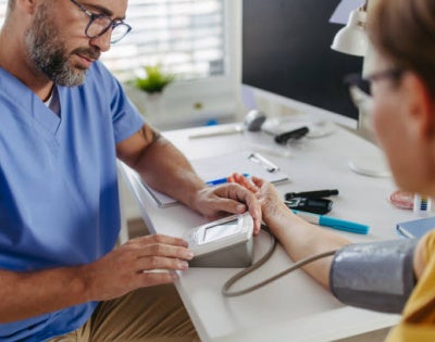 Image of a doctor recording patient's cholesterol levels