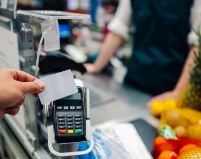 Image of a credit card being tapped on card payment machine