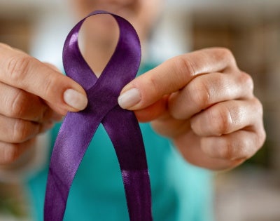 Woman holding purple ribbon 