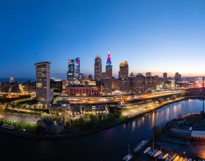 Panoramic view of the Cleveland skyline at dusk with the buildings lit up