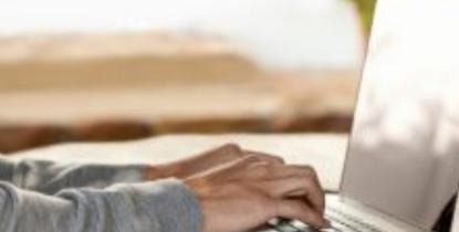 Hands typing on a laptop