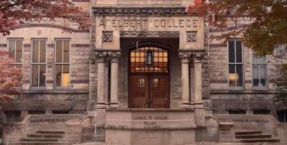 Adelbert Hall surrounded by red fall foliage with a light layer of snow. 