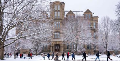 Students walk in front of Case Western Reserve University's Adelbert Hall on a snowy day