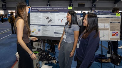 Photo of students presenting a poster at Intersections in fall 2025