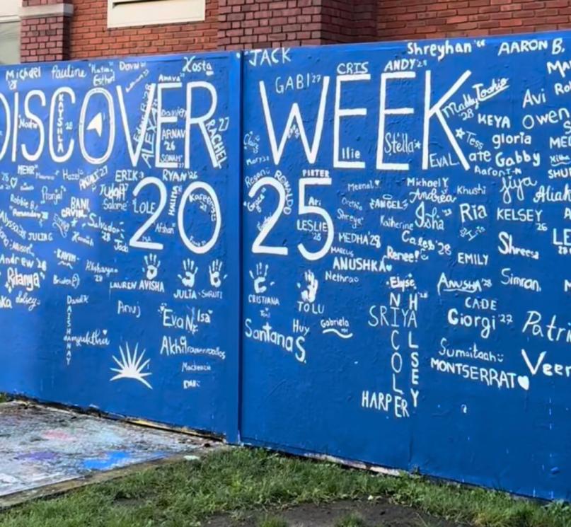 A large blue wall outside the Tinkham Veale University Center, signed by CWRU orientation leaders in white paint.