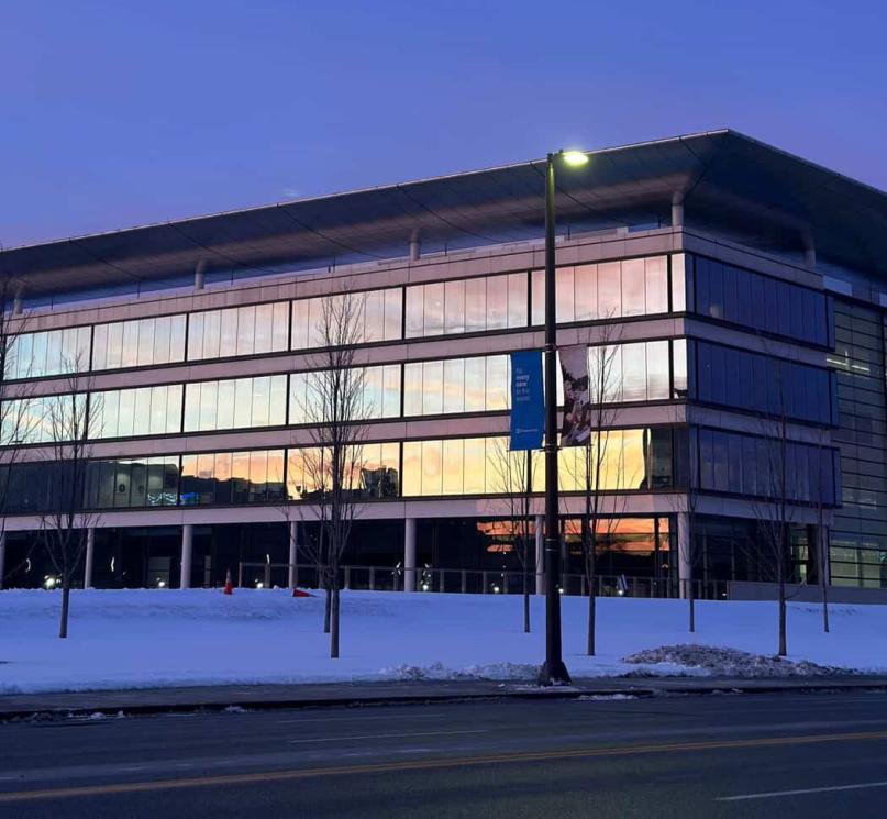 The sunset reflecting off the snowy Sheila and Eric Samson Pavilion building.
