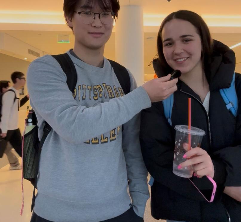 Two students sharing a mini microphone in Tinkham Veale University Center.