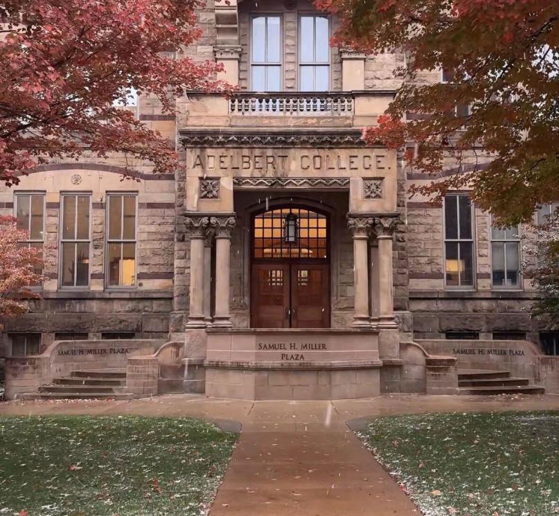 Adelbert Hall surrounded by red fall foliage with a light layer of snow. 