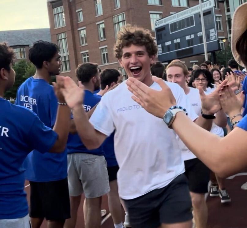 A student running and high-fiving other students.