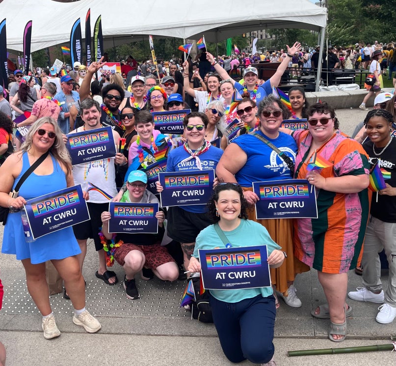 A group of CWRU community members in downtown Cleveland holding a Case Western Reserve University sign at the city’s LGBTQ+ pride event.