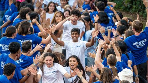 Photo of CWRU Class of 2029 students running through a tunnel of orientation leaders during Discover Week