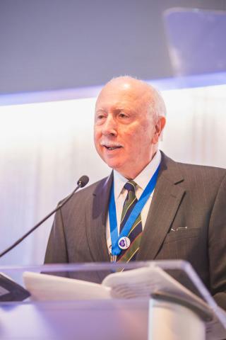 William J. Chiego speaks at a podium during the Alumni Award luncheon