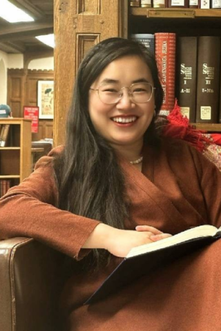 Yuan Gao in a library with a book in their hands