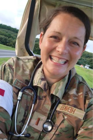 Abby Henkel, RN smiles in military fatigues