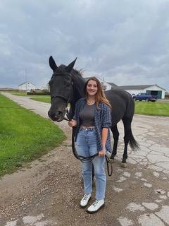 Maggie Kaniecki standing with a horse