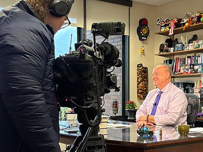 Photo of cameras pointed at Michael Benza as he talks to the media