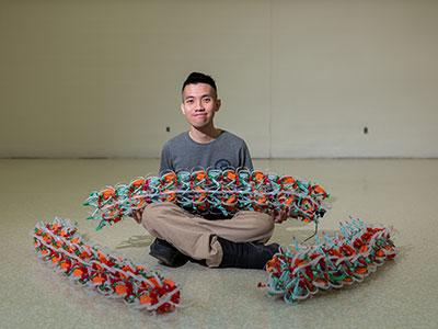 Photo of a student holding a robotic design from the Daltorio lab