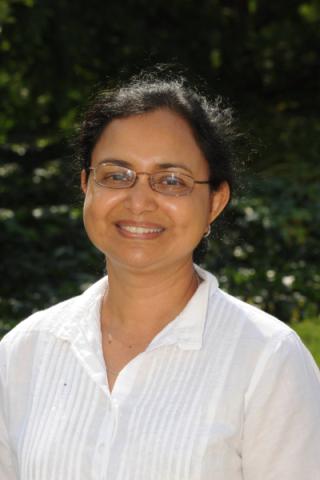Suchitra Nelson, PhD poses in a white shirt.