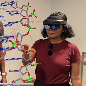 Divita Mathur working with a computer-generated 3D DNA helix