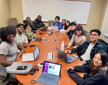 group of students around a table smiling
