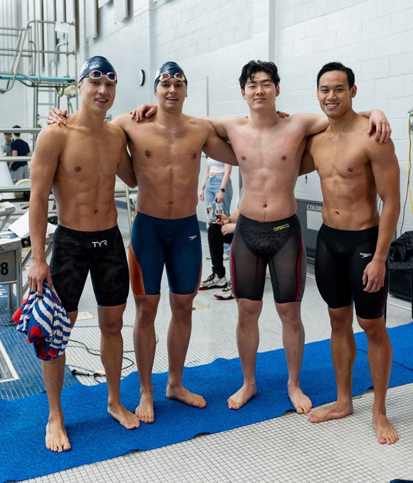 Group of four Case Western Reserve University men's swimmers posing after a race