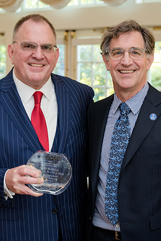 James McAleese posing with his Distinguished Professional Achievement Award