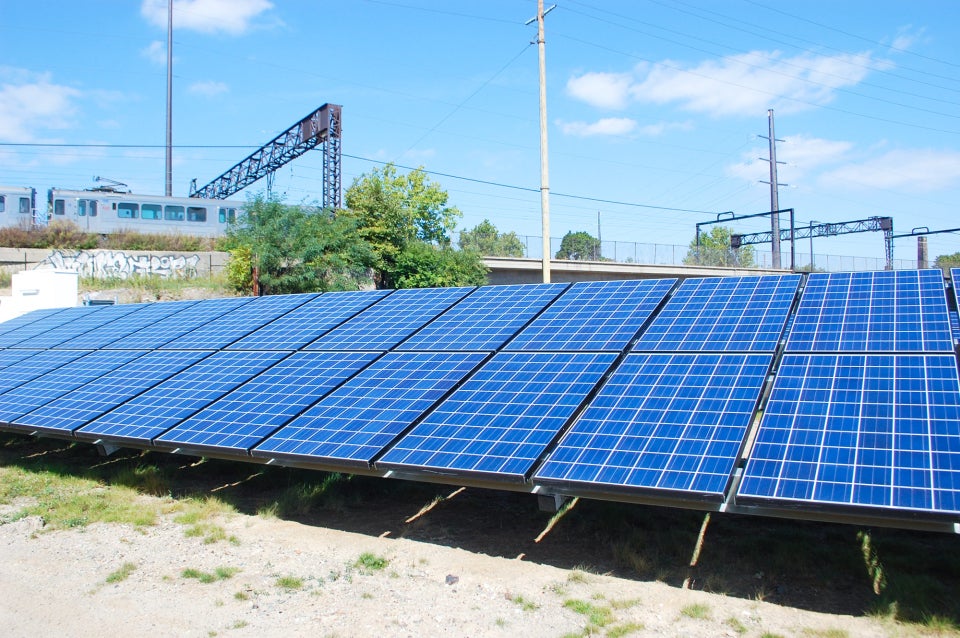 Photograph of rows of solar panels aligned in a field at a photovoltaic power plant in Cleveland.