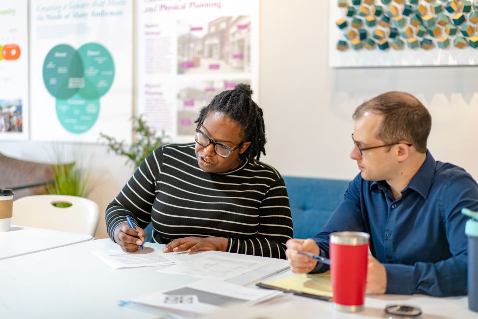 Will Clinics members and others at tables to help people write their wills.