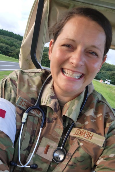 Abby Henkel, RN smiles in military fatigues