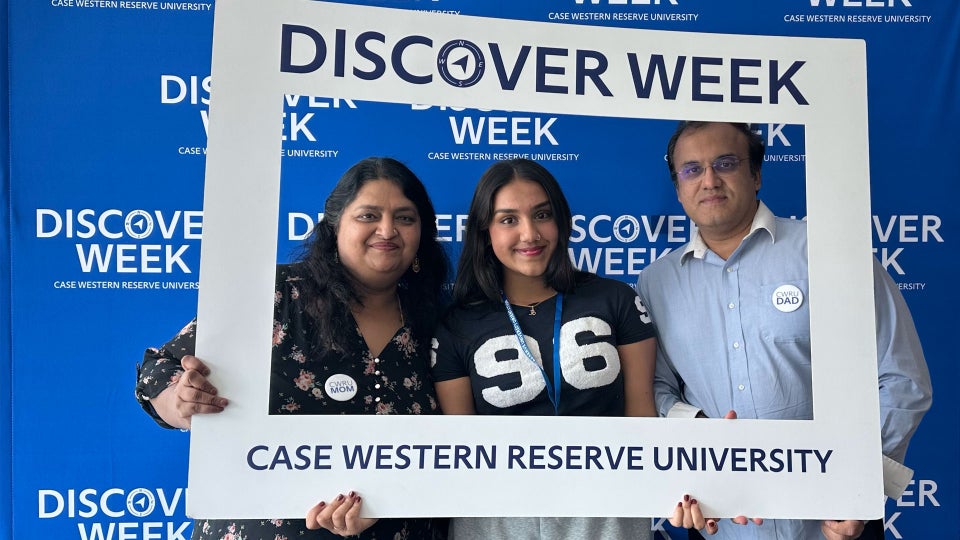 Three people look through a white frame they’re holding that displays the text Discover Week Case Western Reserve University