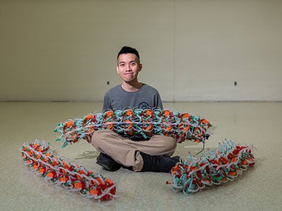 Photo of a student holding a robotic design from the Daltorio lab