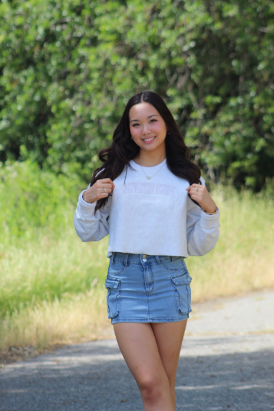 Nursing student Alicia Lee poses against a green nature background.