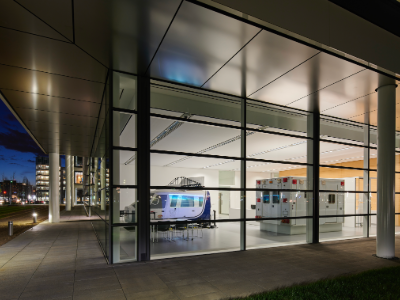 Helicopter and ambulance flight simulators are lit inside a glass-walled building.