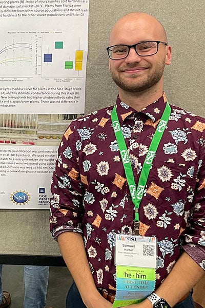 Photo of Sam Harbol in front of a poster presentation